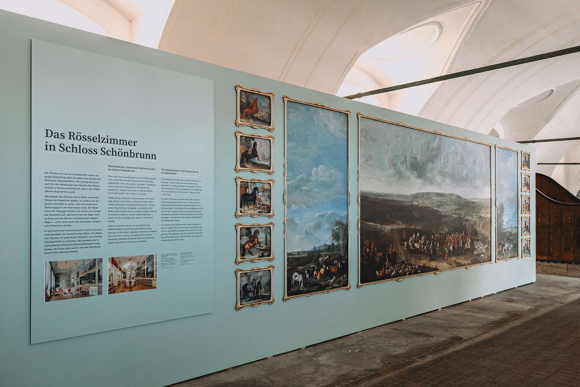 Ausstellungswand mit Infos zum Rösselzimmer und vielen Gemälden