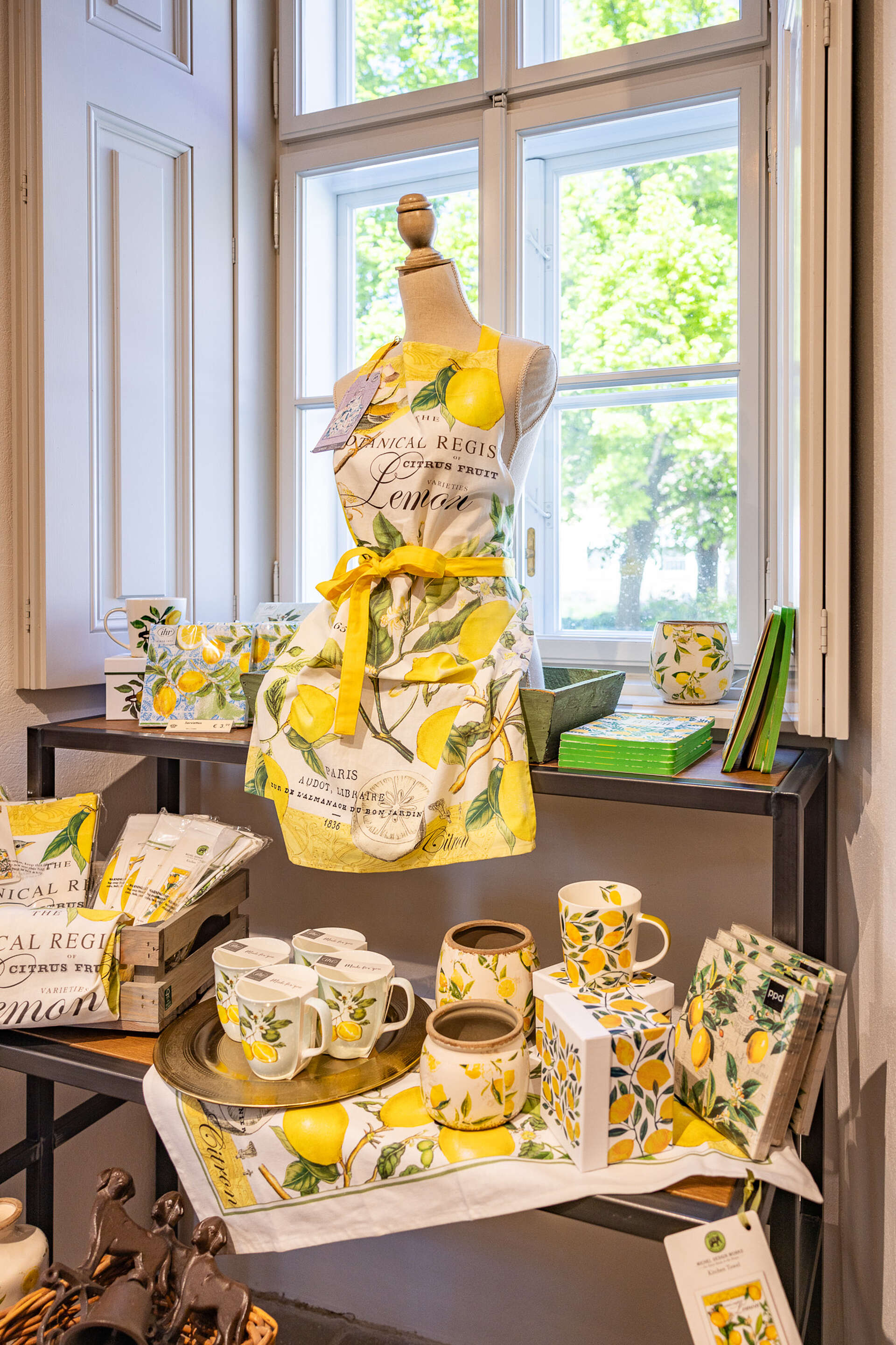 Selection of lemon-themed products: mugs, aprons, napkins, vases