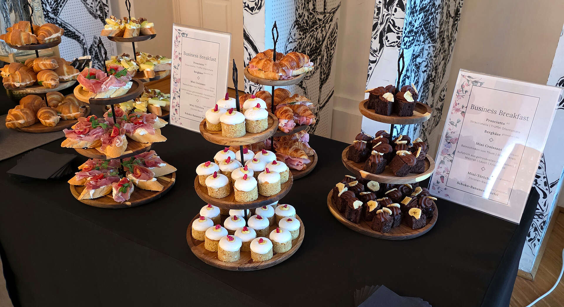 Tisch mit kleinen Brötchen und Desserts